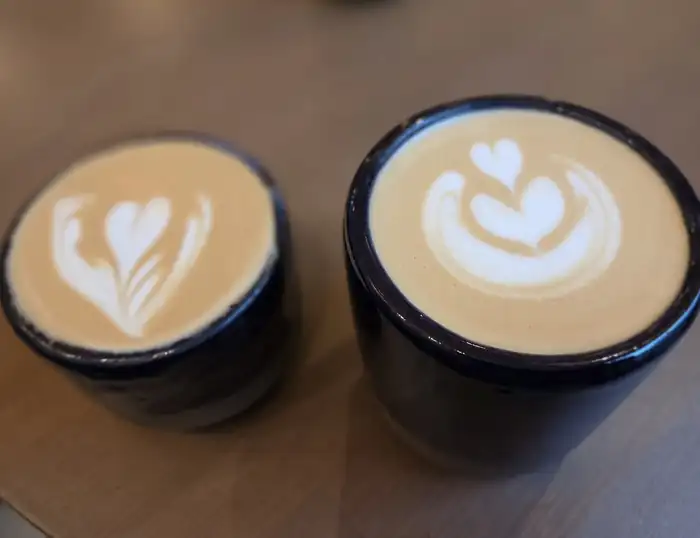 Dwie filiżanki latte z rysunkiem na piance